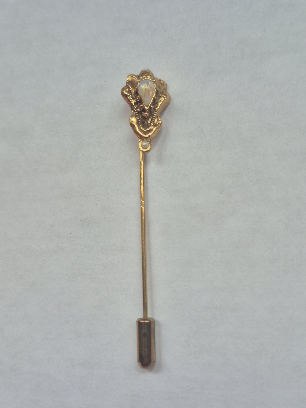 Vintage gold-tone stick pin with pear-shaped iridescent opal stone.